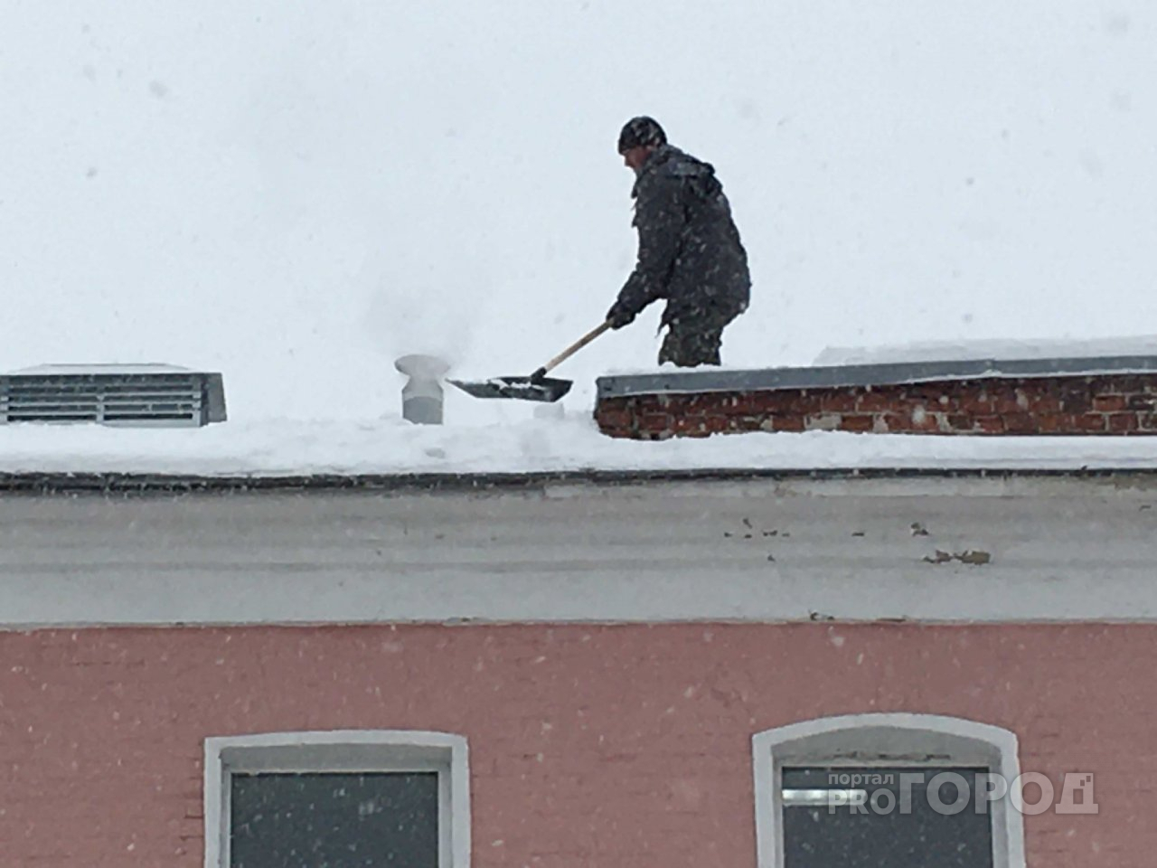В центре города рабочий чистил снег с крыши без страховки